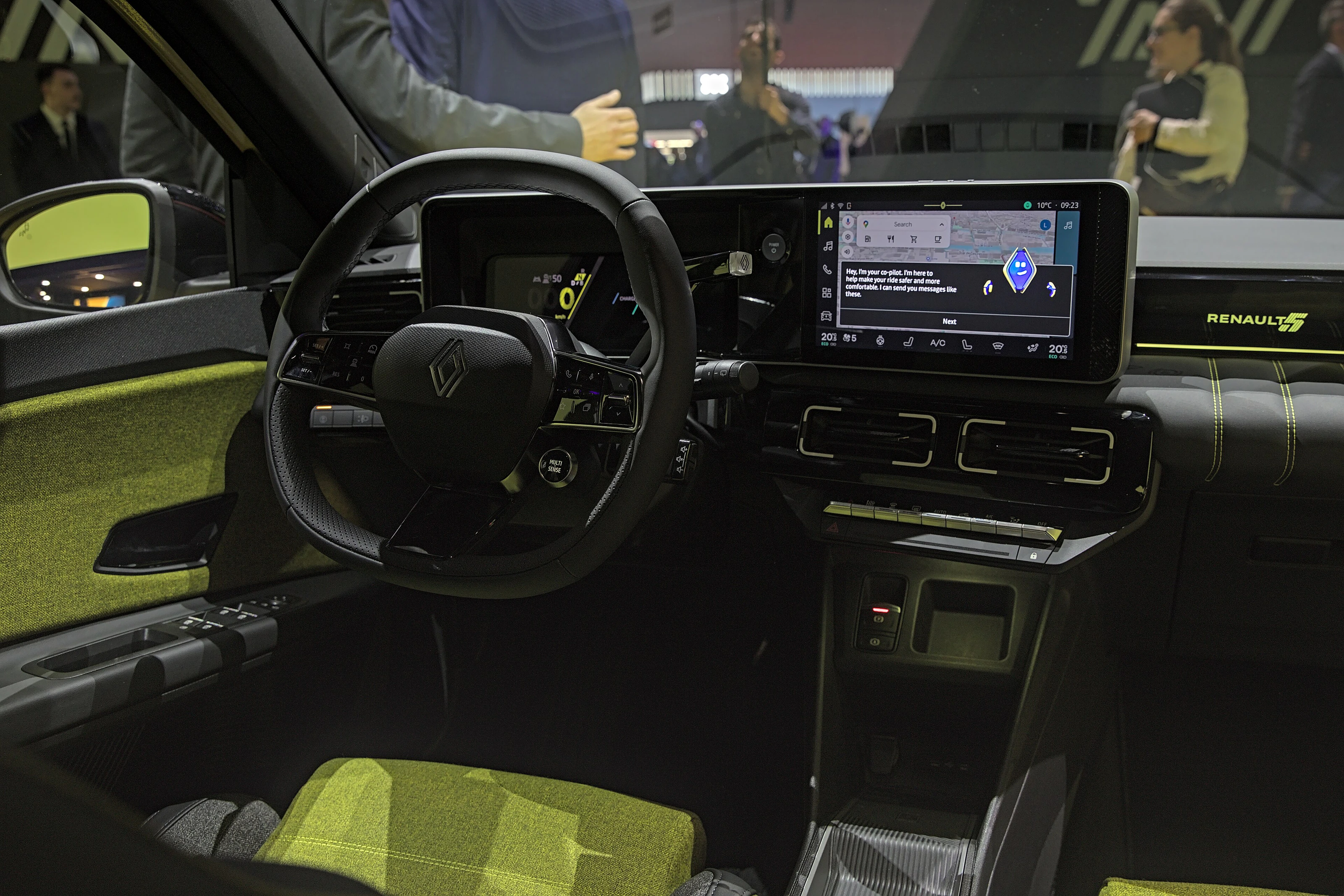 Renault 5 cabin with yellow-accented textile upholstery, steering wheel and central display